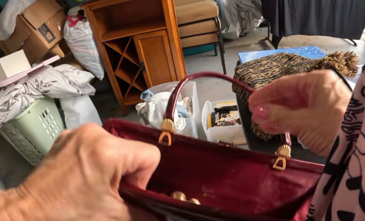 Gold-tone necklace beads peeking out of a burgundy purse